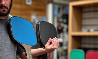 Person holding various pickleball paddles, learning how to choose.
